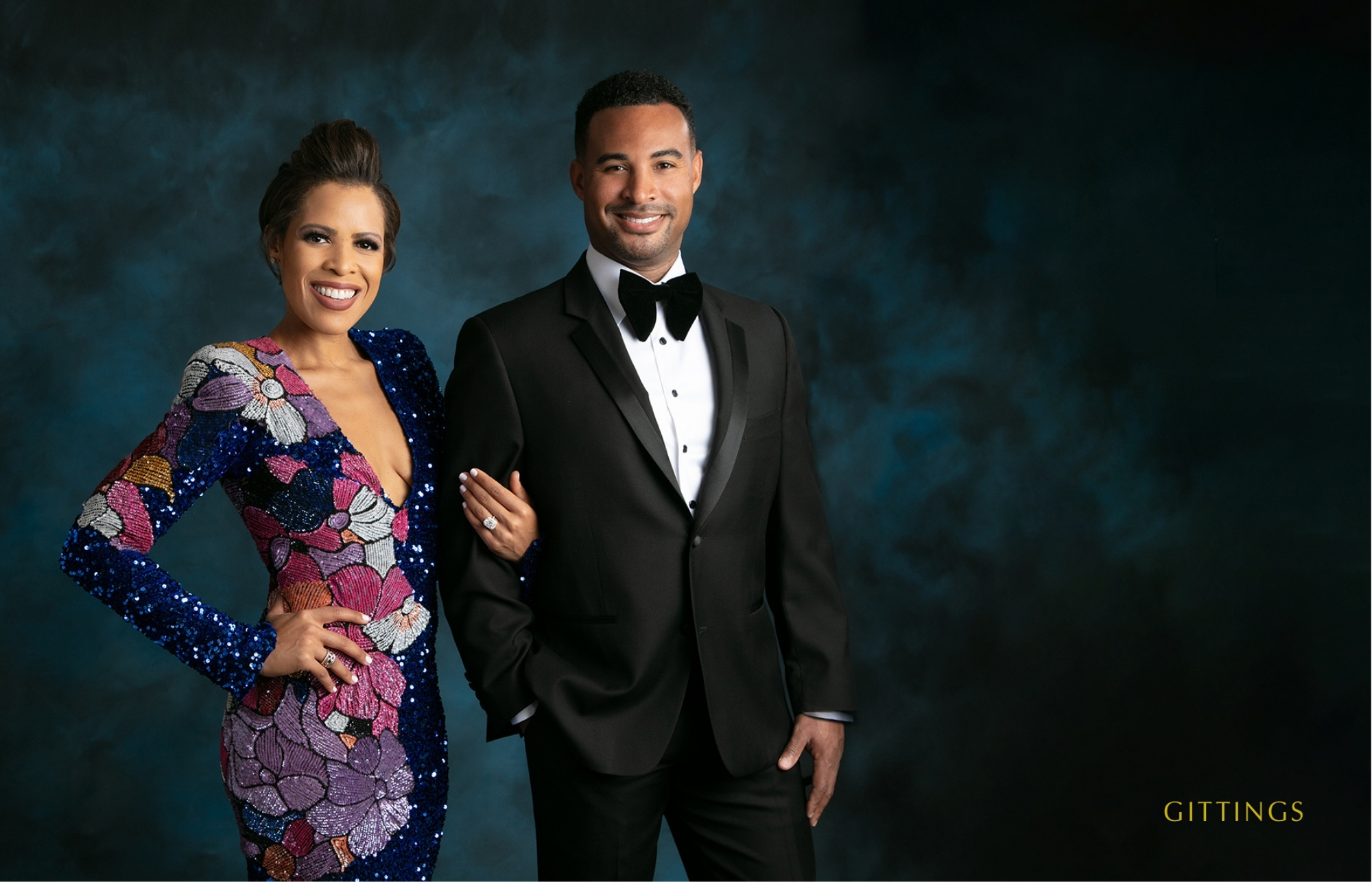 Elegant Couple In Formal Attire, With The Woman In A Sequined Gown And The Man In A Tuxedo, Posing In A Studio Portrait.